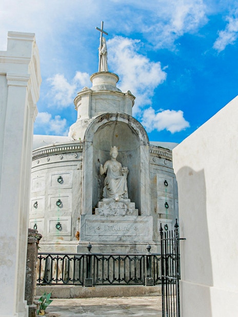 Tomb with statue and cross inside St. Louis Cemetery, New Orleans.