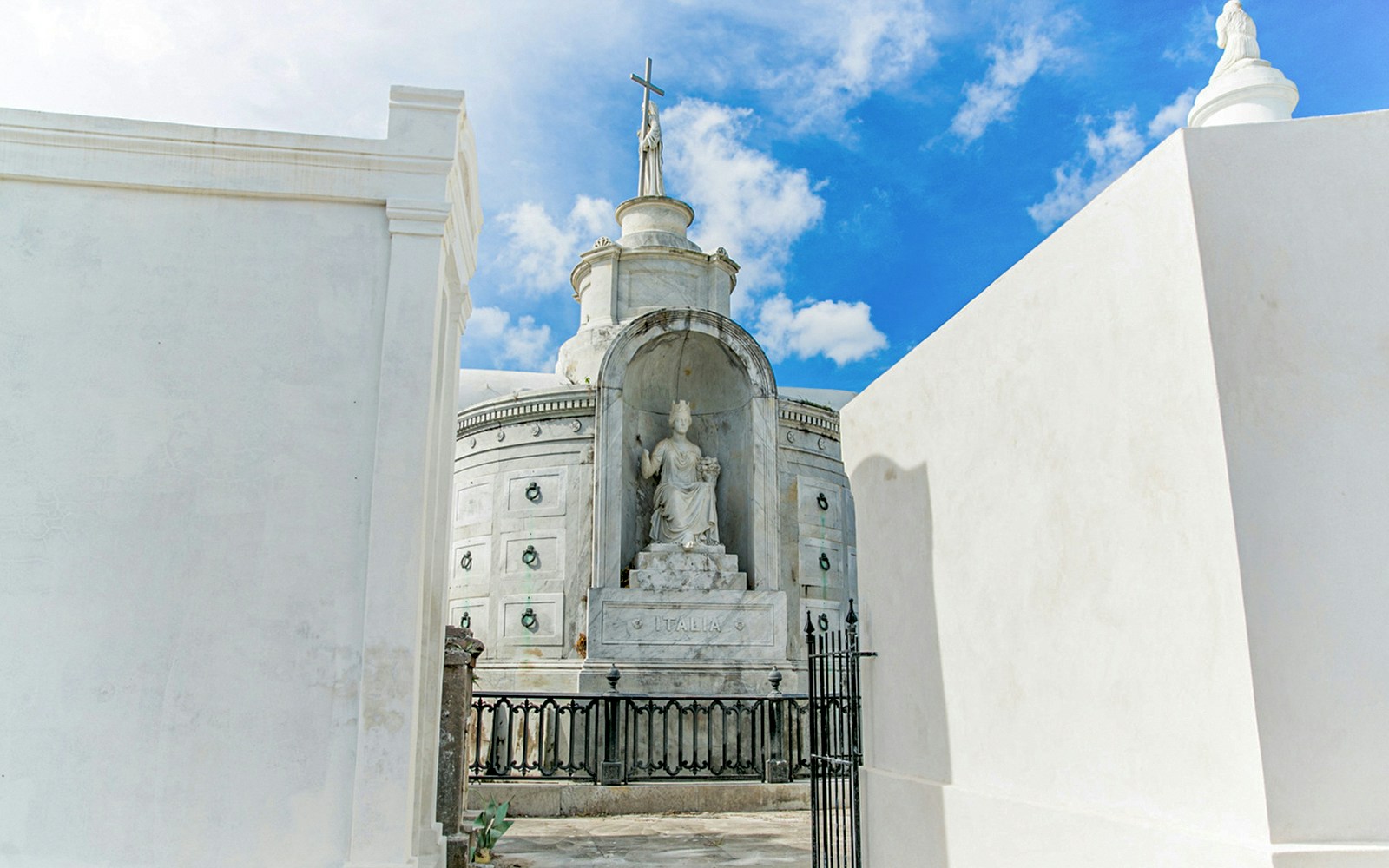 Tomb with statue and cross inside St. Louis Cemetery, New Orleans.