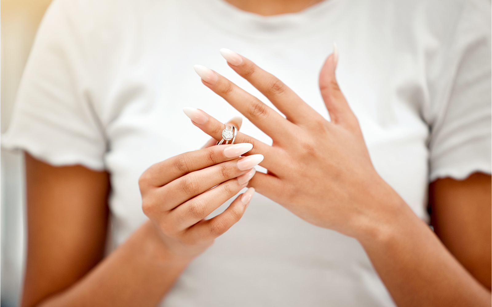 Woman removing a ring from her finger.