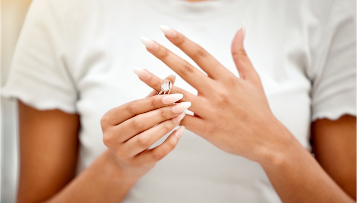 Woman removing a ring from her finger.