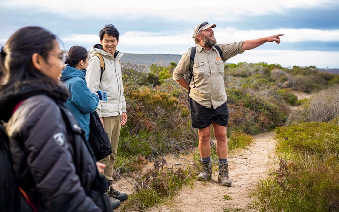 Tour guide leading group on Bruny Island nature trail, Hobart adventure tour.