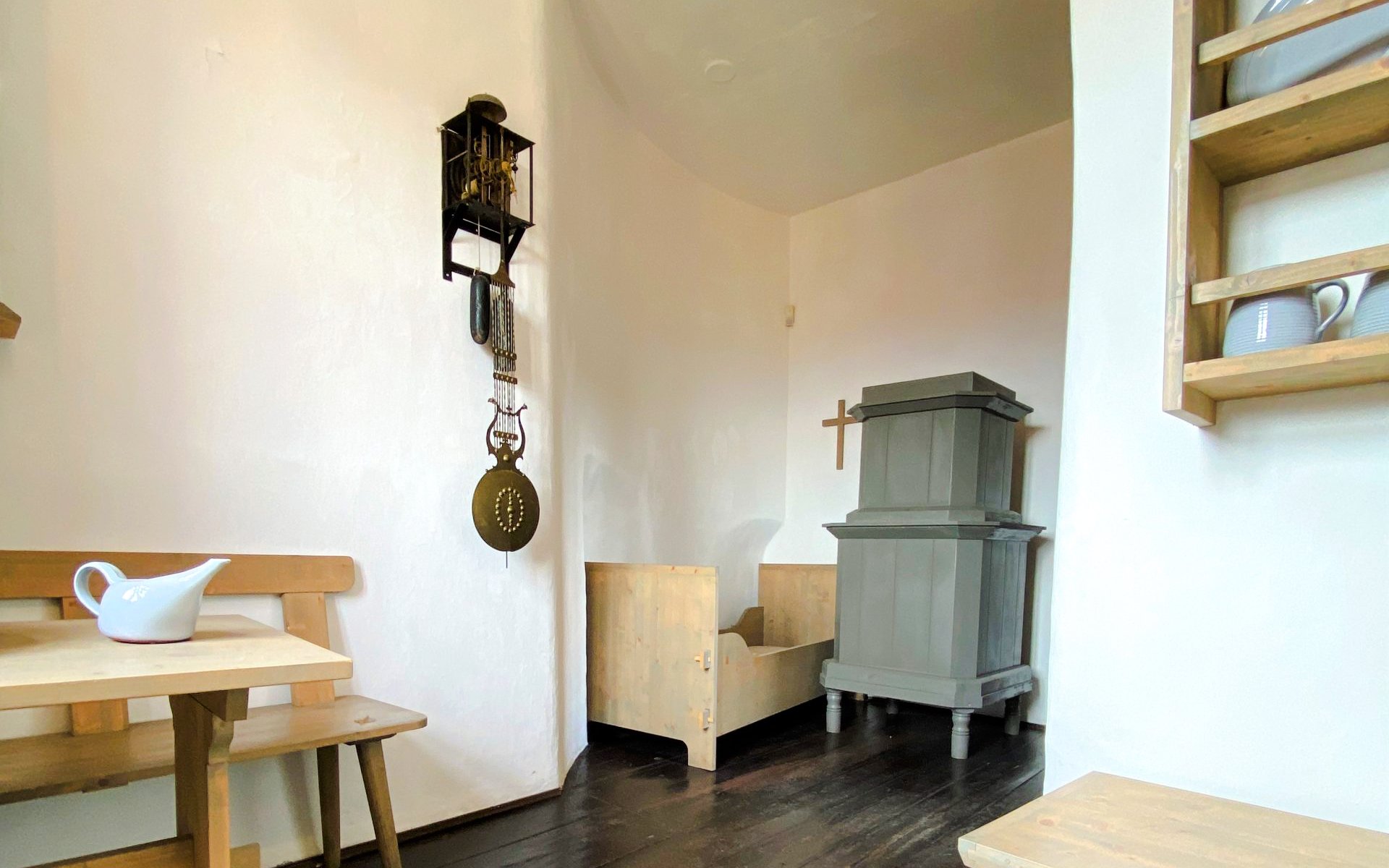Watchmaker's Quarters interior with clock mechanism, wooden furniture, and stove in Nicholas Bell Tower, Prague.