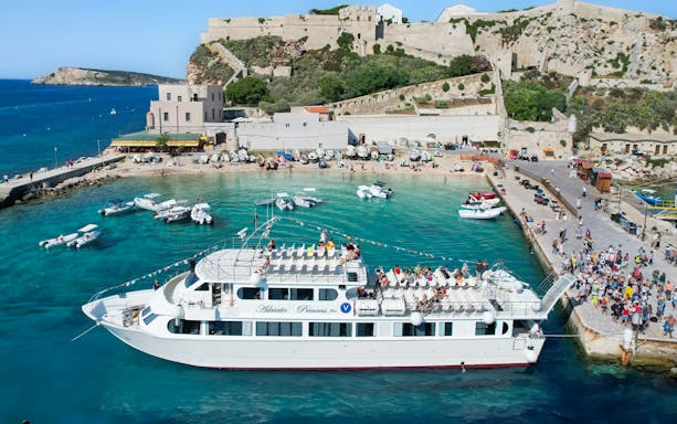 Ferry docked at Tremiti Islands with passengers boarding for Navitremiti round trip transfer.