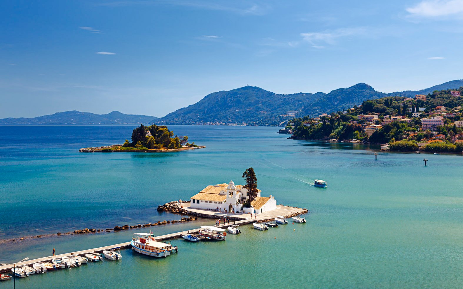 Mouse Island and Vlacherna Monastery in Corfu, Greece, with boats docked nearby.
