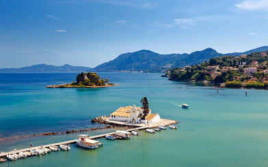 Mouse Island and Vlacherna Monastery in Corfu, Greece, with boats docked nearby.