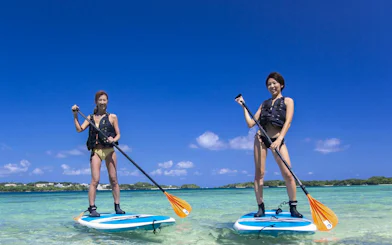 Two people paddleboarding on clear waters at Kabira Bay, Ishigaki, Okinawa.