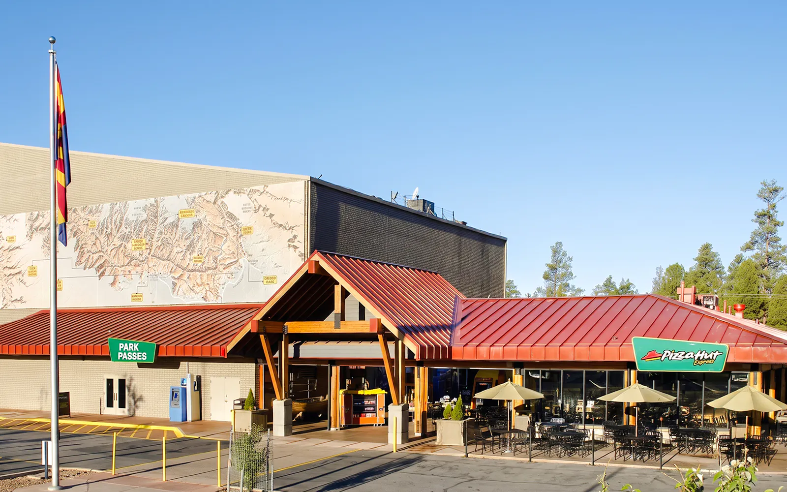 Grand Canyon IMAX theater entrance with map mural and outdoor seating area.