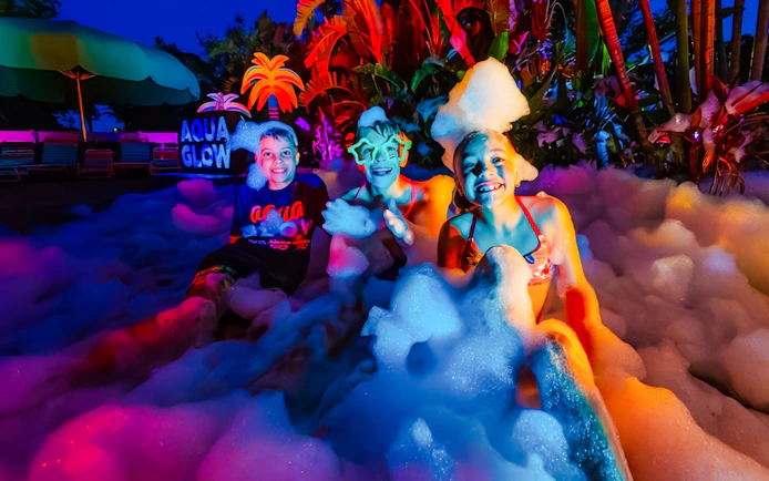 Children enjoying foam party at AquaGlow, Adventure Island Tampa.