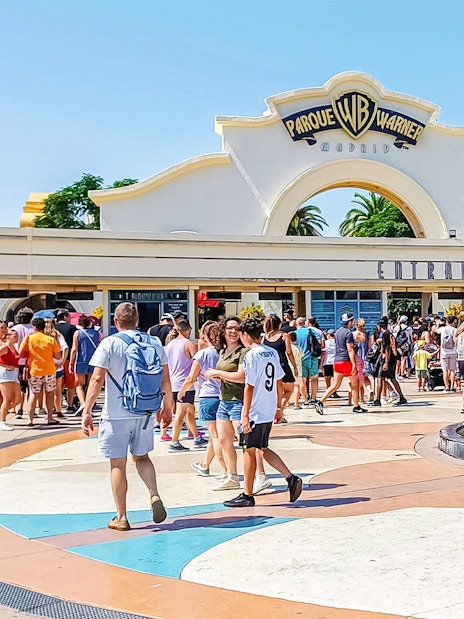 Crowd at entrance of Parque Warner Madrid with fountain in foreground.