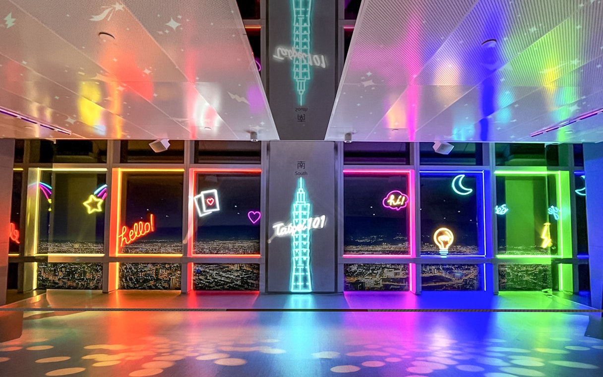 Neon-lit Taipei 101 Observatory interior with city view, Taiwan.