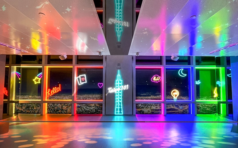 Neon-lit Taipei 101 Observatory interior with city view, Taiwan.