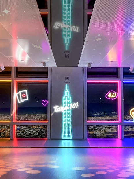 Neon-lit Taipei 101 Observatory interior with city view, Taiwan.