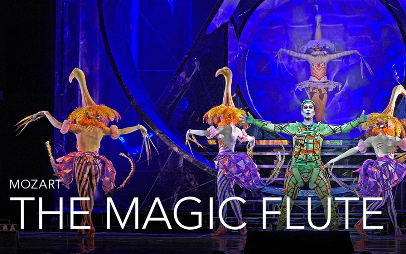 Performers in colorful costumes on stage during "The Magic Flute" opera.