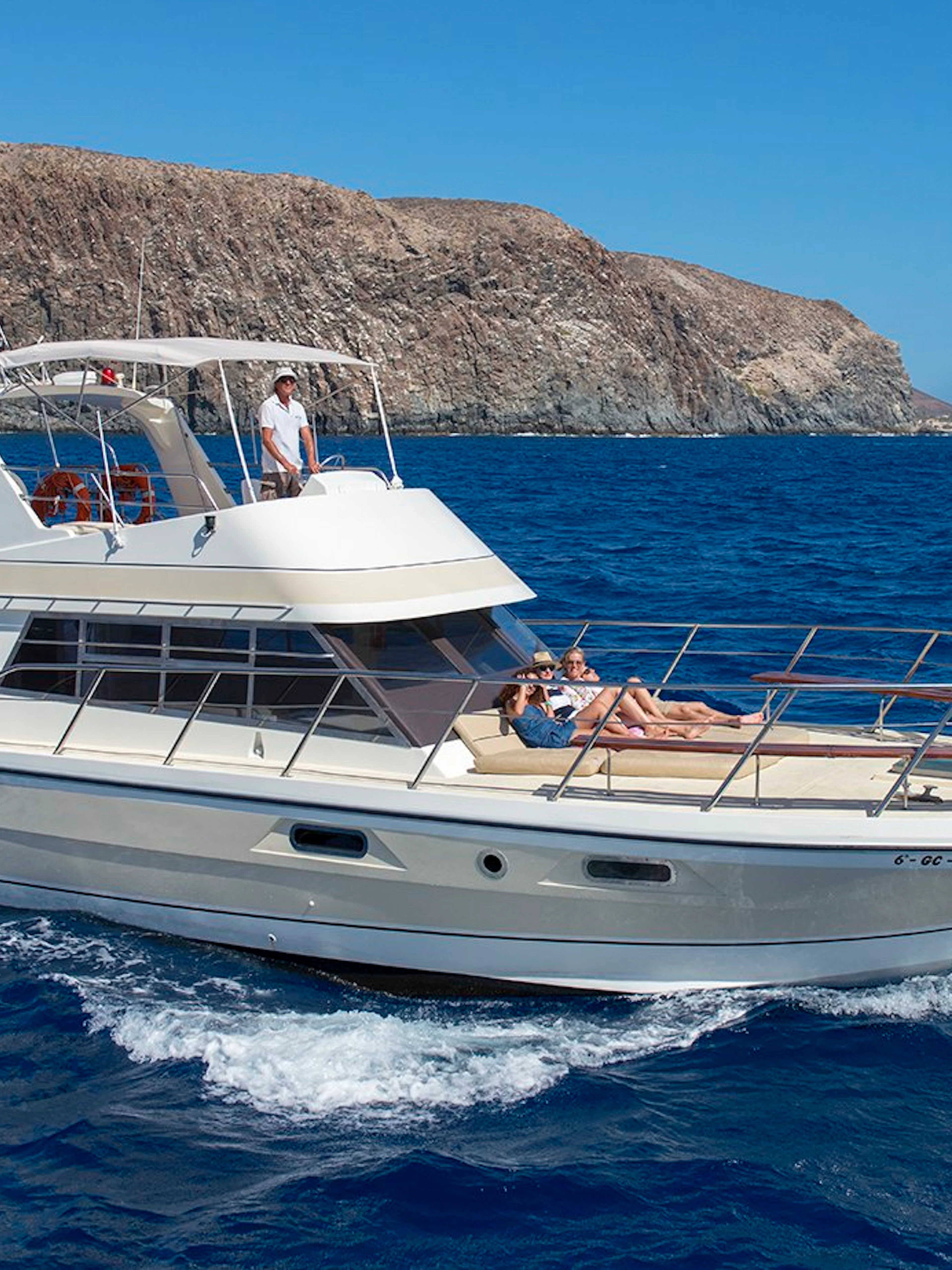 Tourists relaxing on a yacht during whale and dolphin watching in Tenerife.