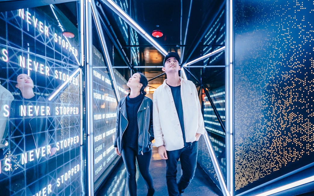 Visitors exploring the illuminated hallway at the Edge Observational Deck in NYC.