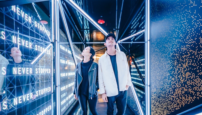 Visitors exploring the illuminated hallway at the Edge Observational Deck in NYC.