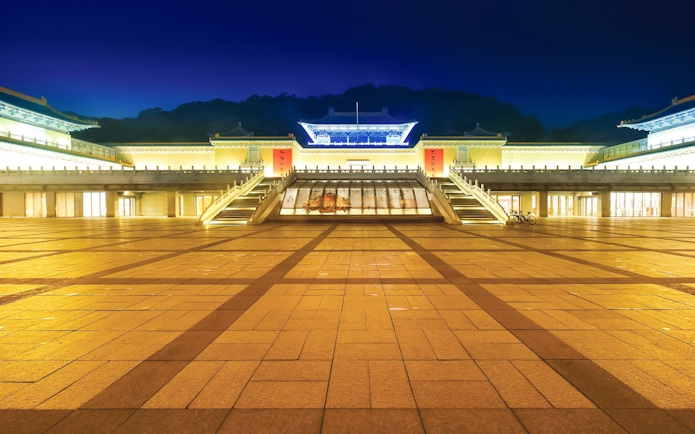 Taiwan Palace Museum illuminated at night with grand entrance and steps.