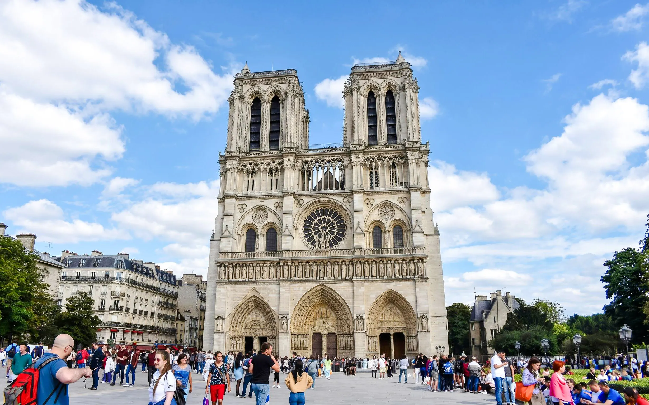 Notre-Dame Cathedral facade with visitors in Paris, France.