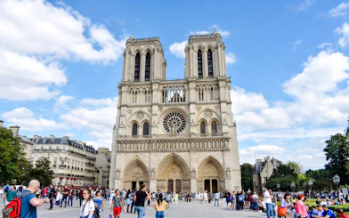 Notre-Dame Cathedral facade with visitors in Paris, France.