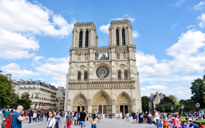 Notre-Dame Cathedral facade with visitors in Paris, France.