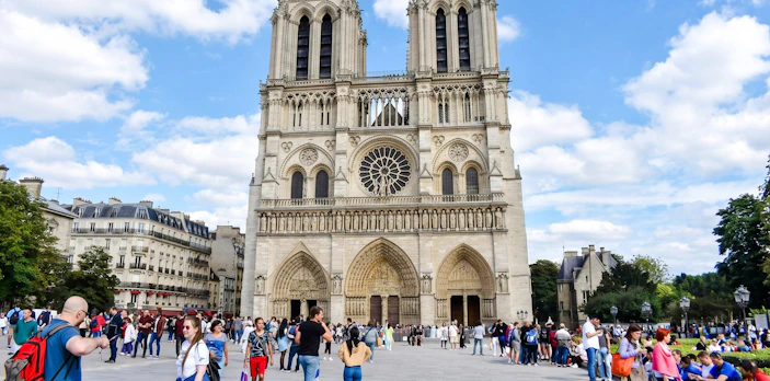 Notre-Dame Cathedral facade with visitors in Paris, France.