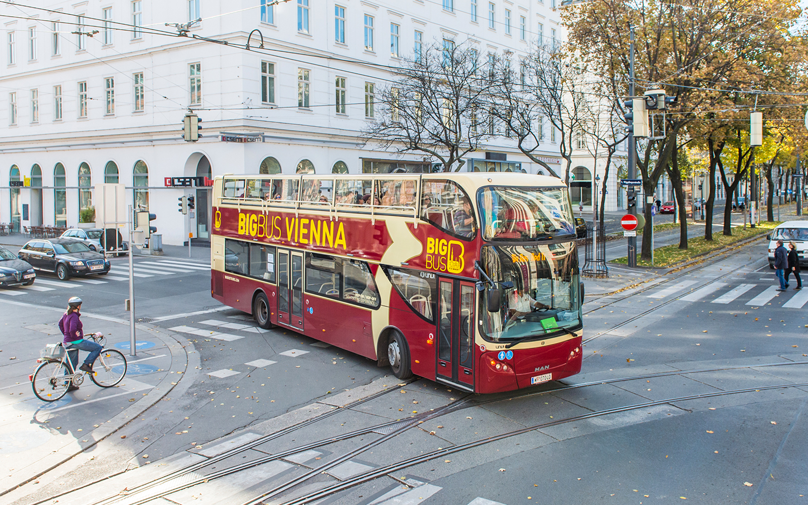 Vienna HopOn HopOff bus on city street near historic buildings.