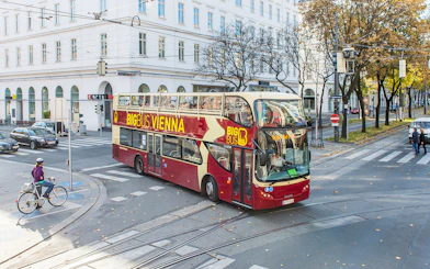 Vienna HopOn HopOff bus on city street near historic buildings.
