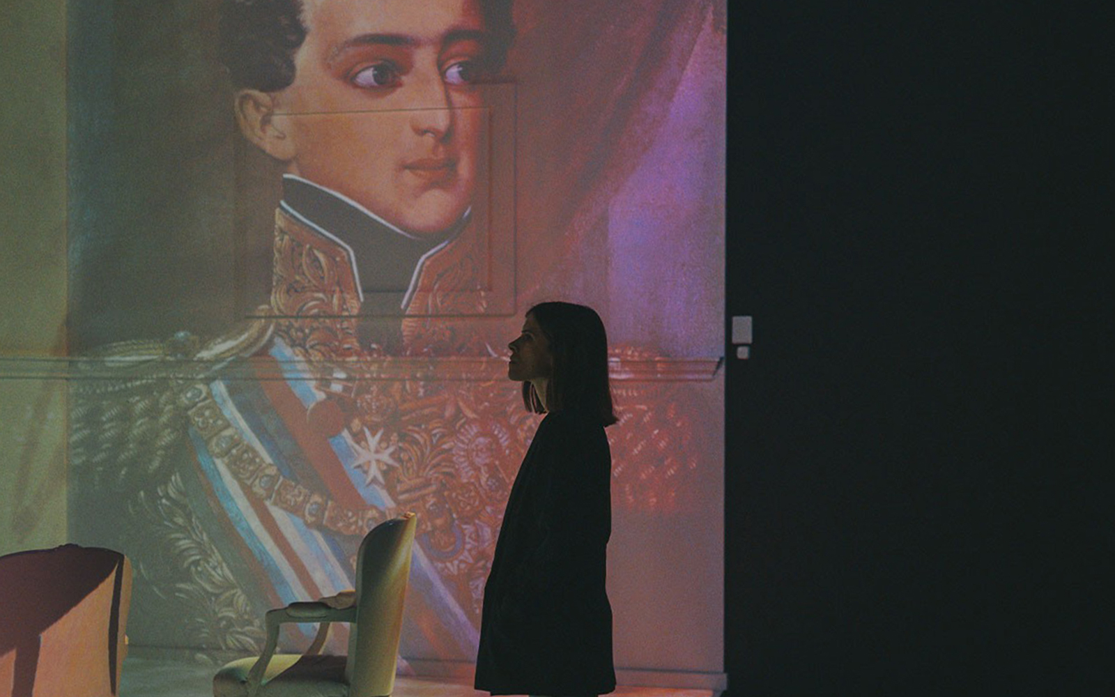 Person observing historical portrait projection in Porto Region Across The Ages Experience.