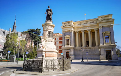 Prado Museum entrance with nearby monument in Madrid, Spain.