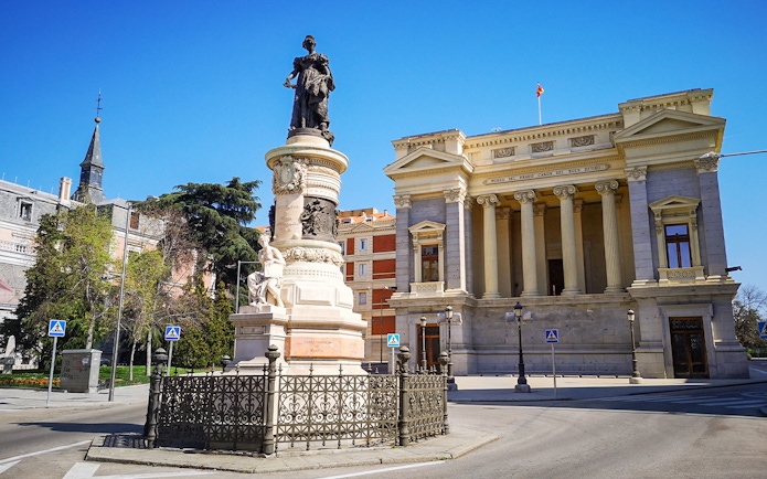 Prado Museum entrance with nearby monument in Madrid, Spain.