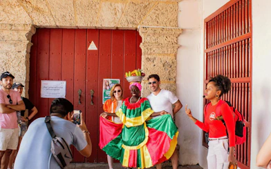 Traditional street performer with tourists in Cartagena's historic center.