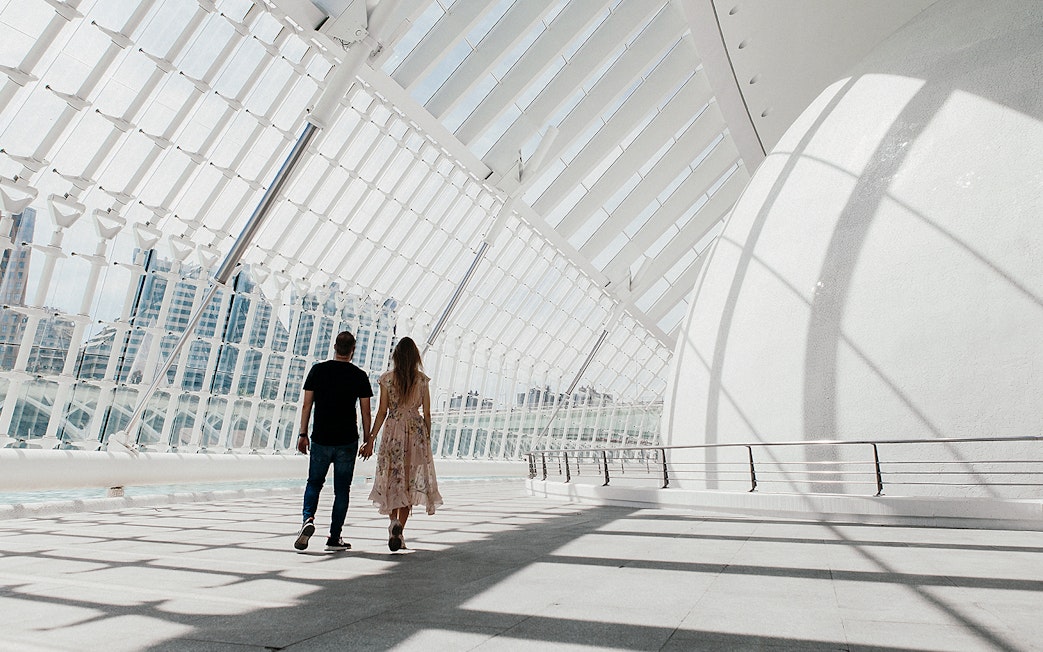 Couple walking inside Hemisfèric building, Valencia's City of Arts and Sciences.