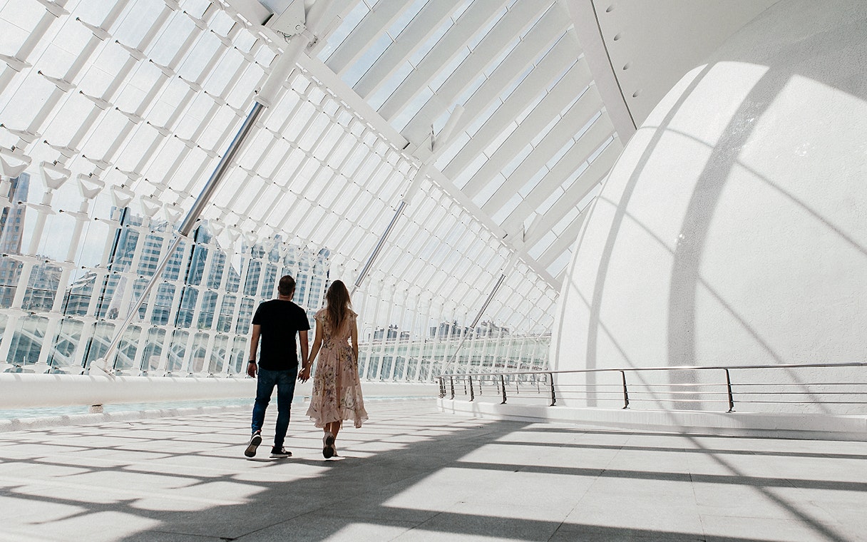 Couple walking inside Hemisfèric building, Valencia's City of Arts and Sciences.