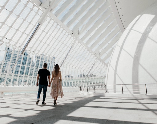 Couple walking inside Hemisfèric building, Valencia's City of Arts and Sciences.