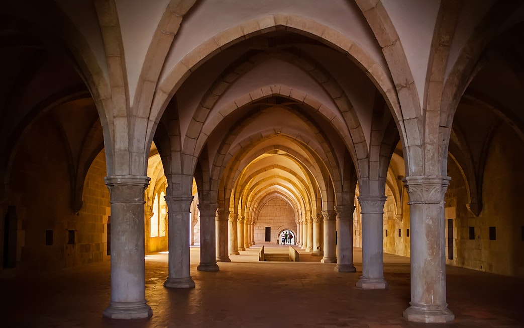 Alcobaça Monastery interior with vaulted arches and stone columns.