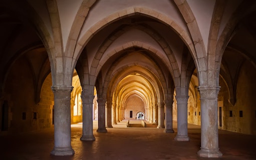 Alcobaça Monastery interior with vaulted arches and stone columns.