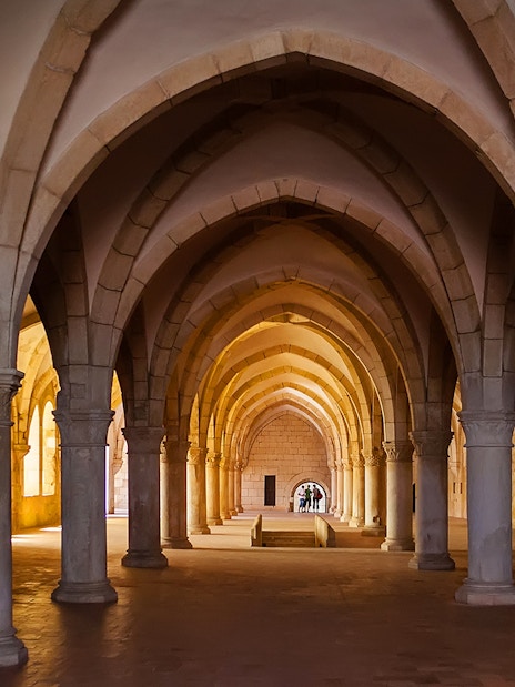 Alcobaça Monastery interior with vaulted arches and stone columns.