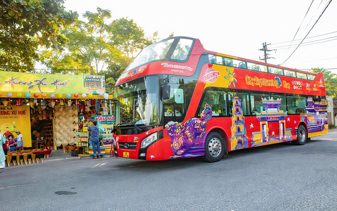 City Sightseeing Hue Hop-On Hop-Off bus near local market in Hue, Vietnam.