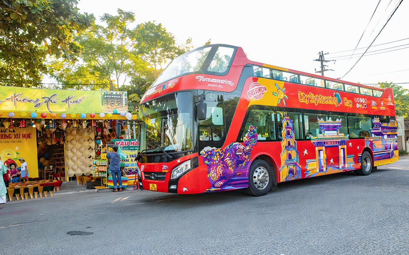 City Sightseeing Hue Hop-On Hop-Off bus near local market in Hue, Vietnam.