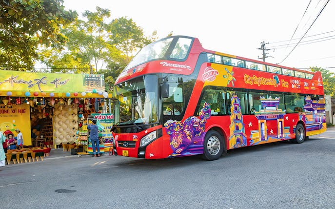 City Sightseeing Hue Hop-On Hop-Off bus near local market in Hue, Vietnam.