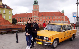 Yellow Fiat 125p in front of Warsaw's Royal Castle.