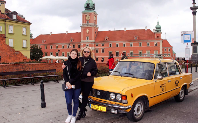 Yellow Fiat 125p in front of Warsaw's Royal Castle.