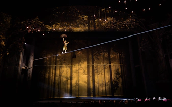 Performer on tightrope during Cirque du Soleil Alizé stage show.