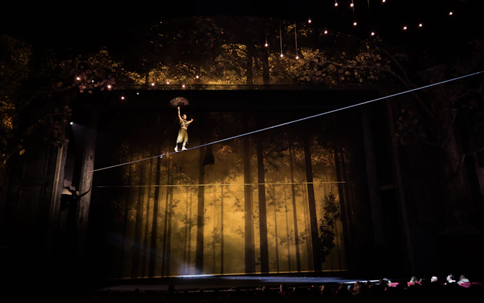 Performer on tightrope during Cirque du Soleil Alizé stage show.