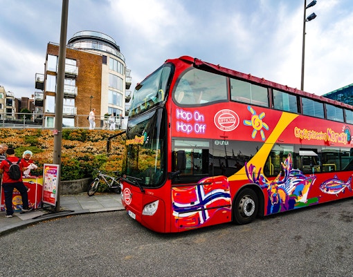 Stavanger City Sightseeing hop-on hop-off bus with colorful design on city street.
