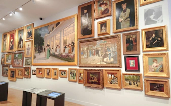 Paintings displayed on a wall at Carnavalet Museum, Paris, showcasing historical art.