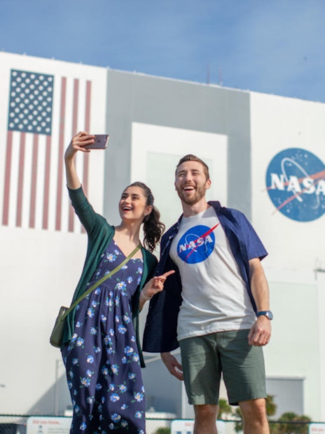 Visitors taking a selfie in front of the Vehicle Assembly Building at Kennedy Space Center.