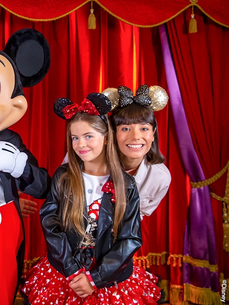 Family posing with Mickey Mouse at Disneyland® Paris.
