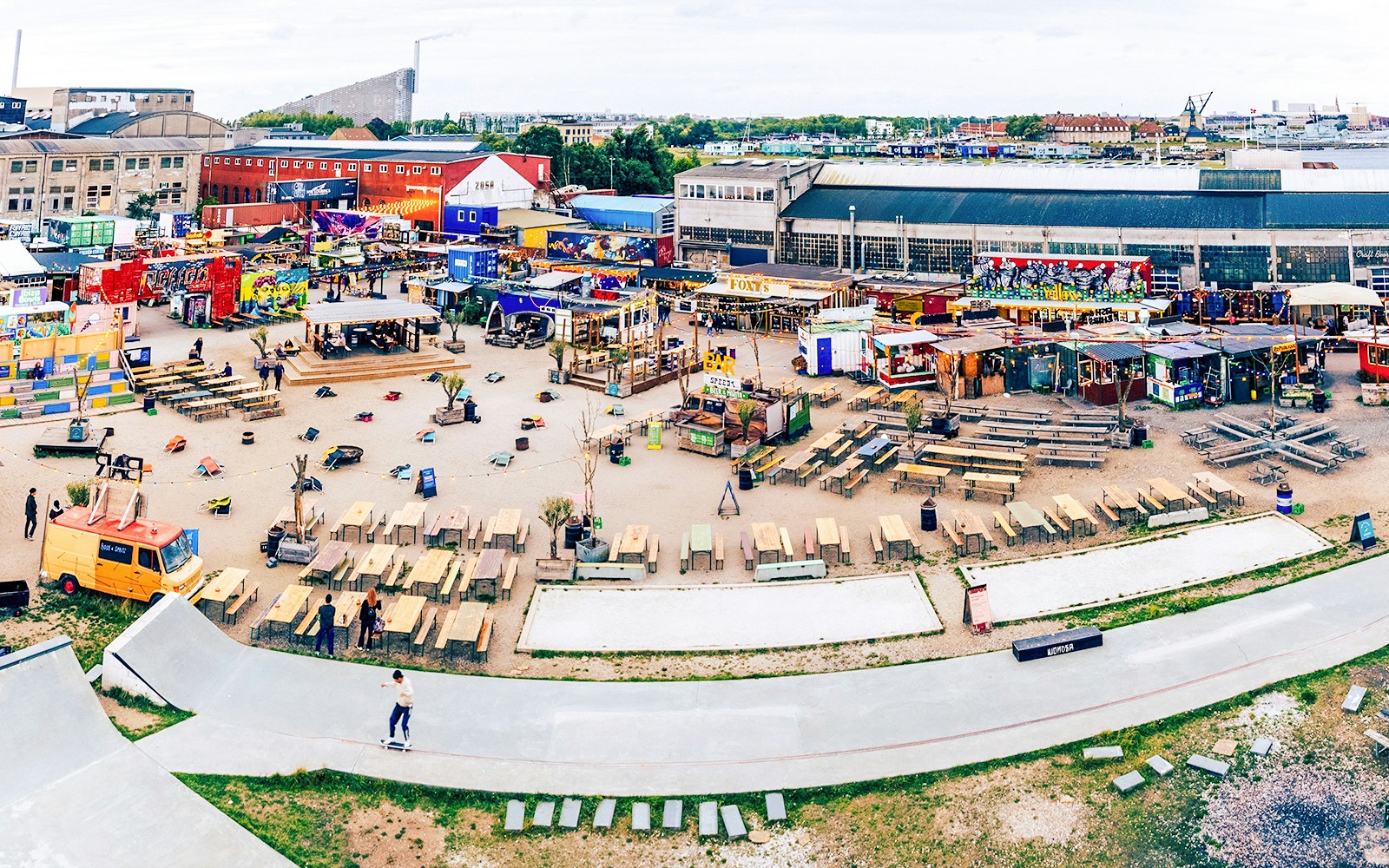 Reffen Copenhagen Street Food market with colorful food stalls and people dining outdoors.