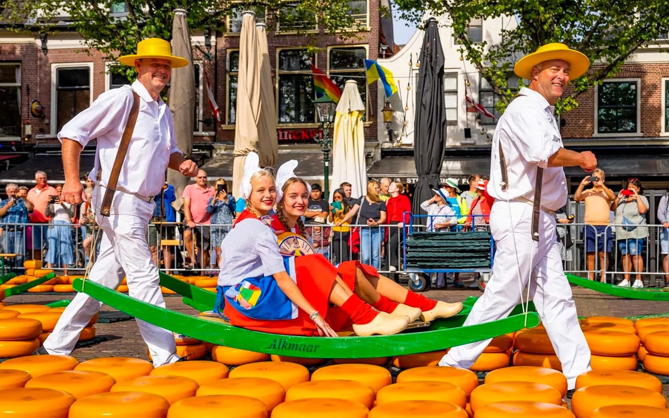 Cheese carriers at Alkmaar Cheese Market with traditional costumes and cheese wheels.